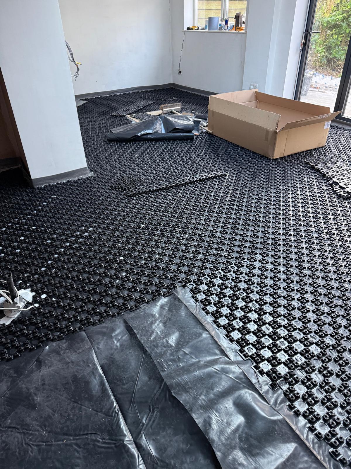 Overlay panel underfloor heating laid across a retrofit room