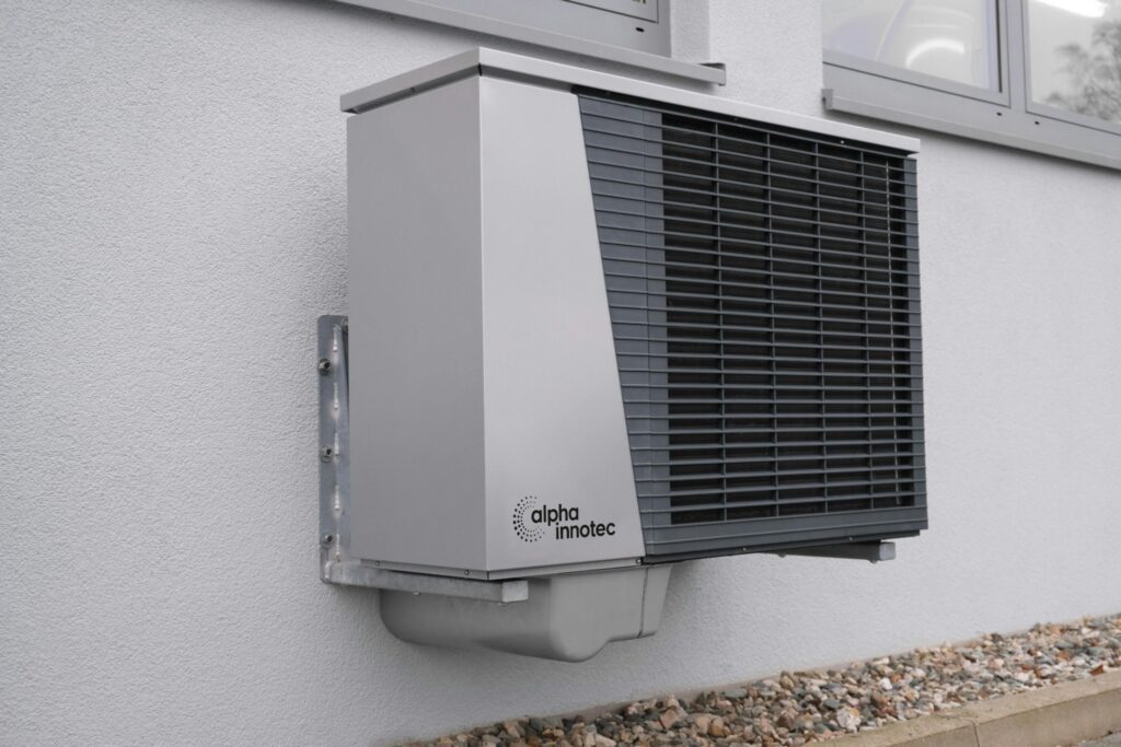 Wall-mounted air source heat pump unit installed outside home